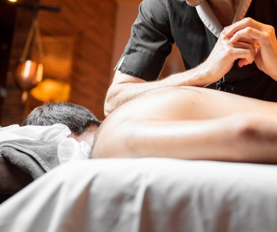 a male therapist massaging a male customer