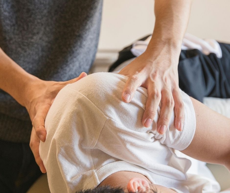 a masseur performing massage on a man's shoulder